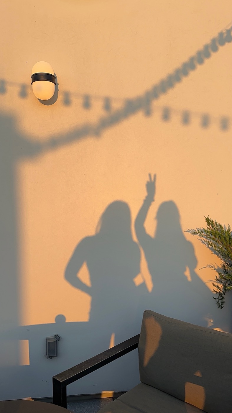 Two friends at golden hour throwing a peace sign